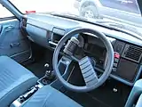 Interieur (Rechtslenker). Der schwarze, waagerecht stehende Griff betätigt die Feststellbremse.