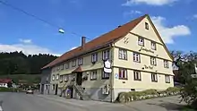 verschindelter Satteldachbau, zweistöckig, aus dem 18. Jahrhundert, an Straße, Gelb bemalt
