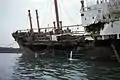 An Backbord ist die Schiffswand bis mittschiffs aufgerissen, die Brücke bis zum Bootsdeck eingedrückt