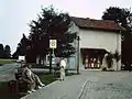 Bahnhofsgelände Marquartstein im August 1996, nach dem Abbau der Gleise und Verlegung der Straße auf das Bahngelände. Links der frühere Gleisbereich, rechts das Empfangsgebäude.