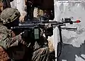Manöverpatronengerät ist auf der Laufmündung eines M249 montiert