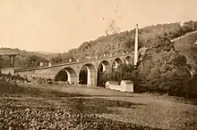 Der 1888 errichtete Viadukt der Nerobergbahn am Ende der heutigen Nerotalanlagen in Wiesbaden, davor ein Holzpavillon, in dem sich ein Studio für Porträtfotografie für Touristen befand, historische Fotografie um 1895