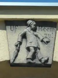 Reichenbach (Eulengeb.) - Zwei Reliefs: (l.) Uf Heem zu! (Auf dem Weg nach Hause)  (r.) Komm mer ock! (Komm mir nur! (Mit dem Finger drohenb.))