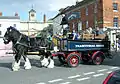 Shire Horse-Gespann vor einem Touristikwagen der Brauerei Wadworth